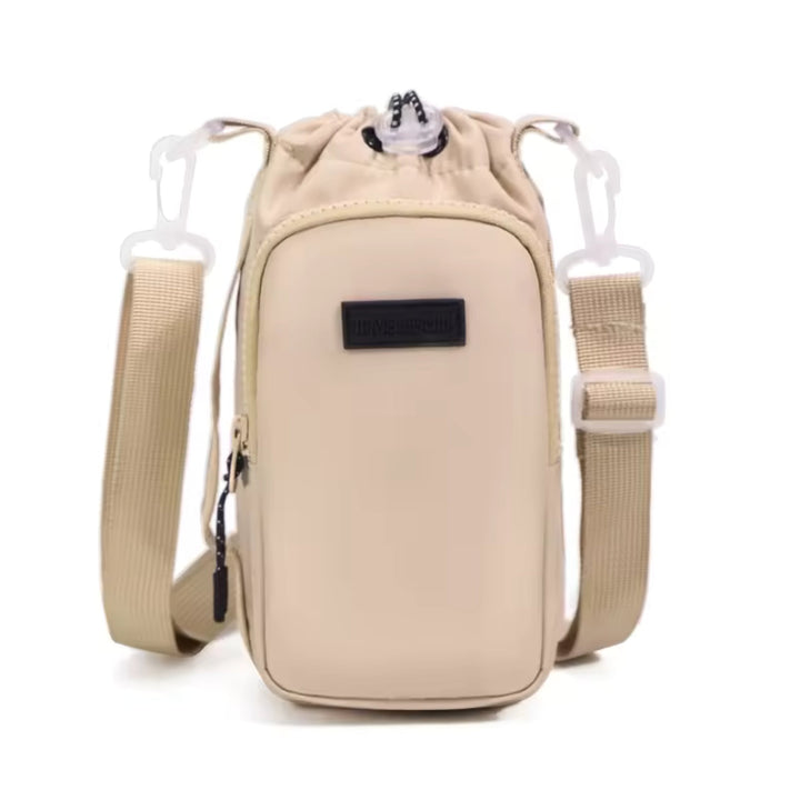 Close-up of the carrier bag's zip pocket and adjustable strap holding a copper water bottle